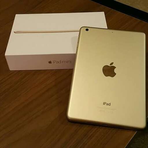 a gold iphone and a white box on a table.