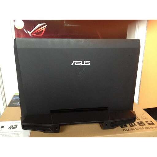 a black laptop sitting on top of a wooden table.