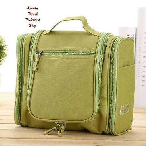 a green suitcase sitting on a wooden floor.