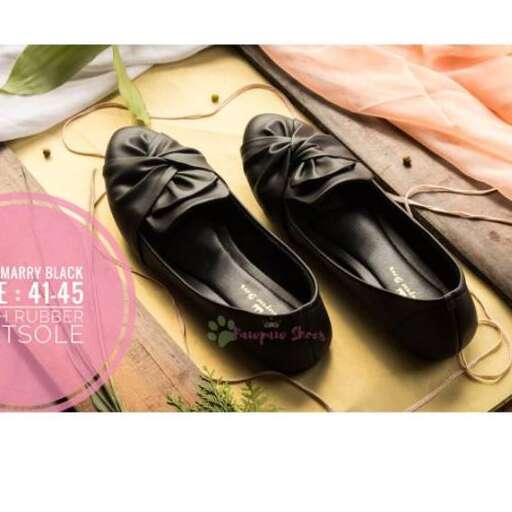 a pair of black flat shoes with a floral pattern.