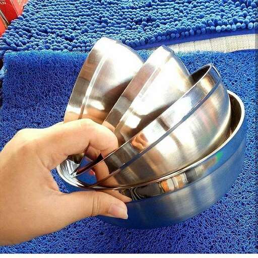 a hand holding a stack of metal bowls.