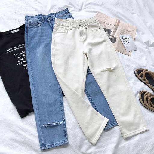 a pair of jeans are on a bed.