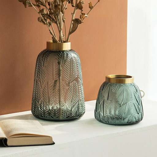 a vase with a book and a book on a shelf.