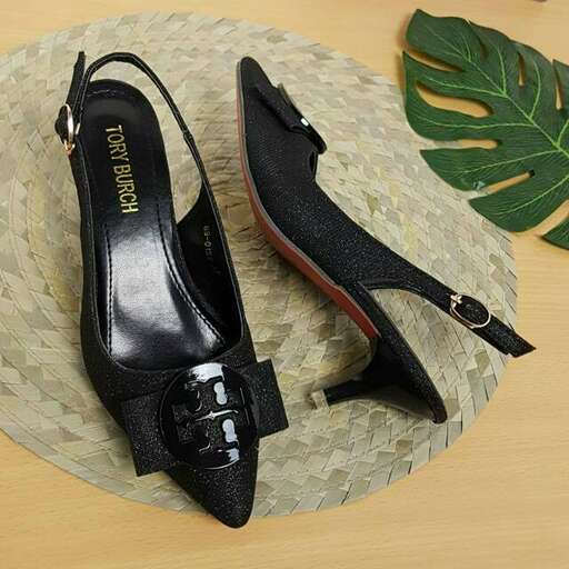 a pair of black shoes with a palm leaf on the side.
