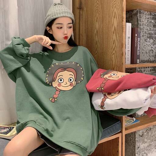a girl in a green sweater and a red pillow