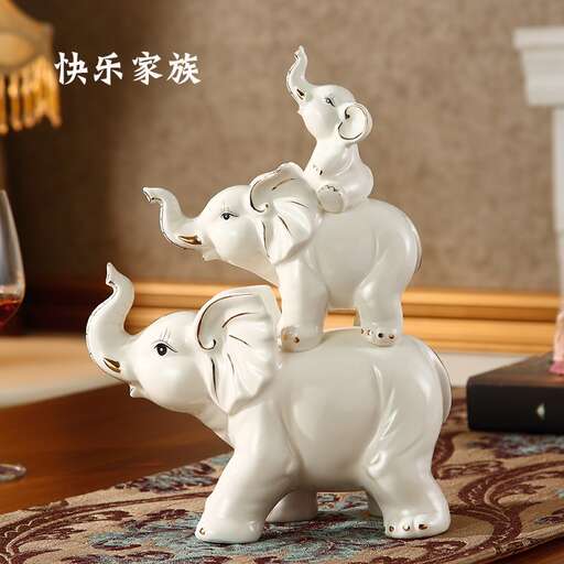 a white elephant statue with two small elephants on top of it.