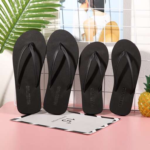 a pair of black flip flops with a pineapple on top.