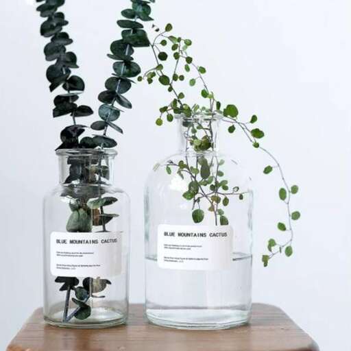 a wooden table with a vase with plants in it.