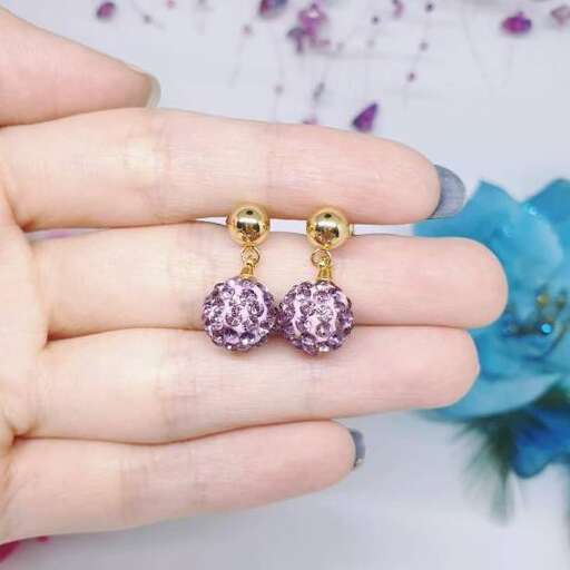 a pair of earrings with a purple sapphire and gold finish.