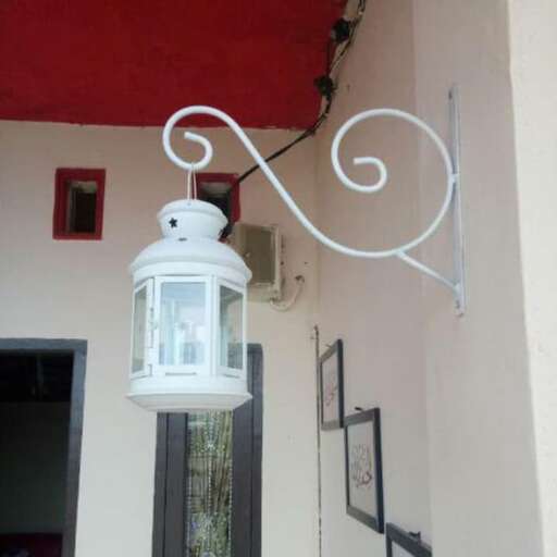 a white lantern hanging from a wall next to a doorway.