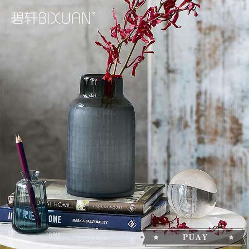 a vase with flowers on top of a stack of books.