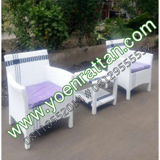 a white plastic chair and a white chair in a garden.