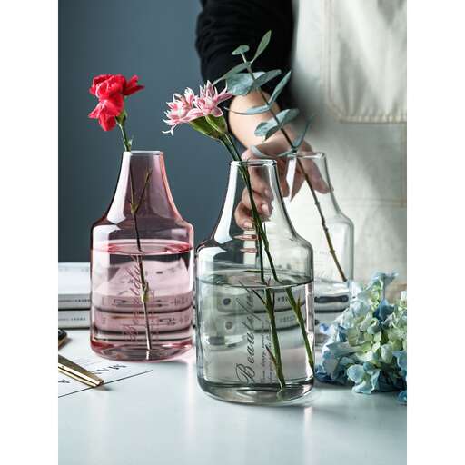 a woman is putting flowers in a vase.