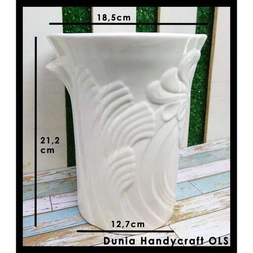 a large white vase sitting on a wooden floor.