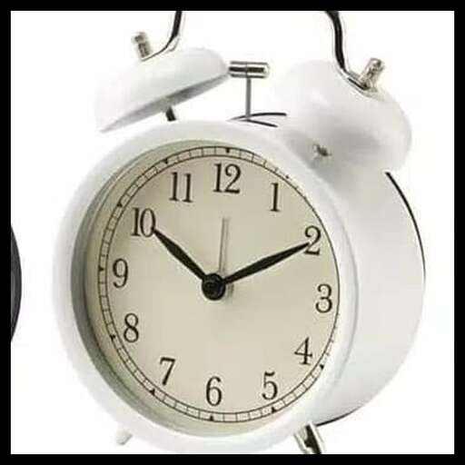a white alarm clock with a black face and a white face.