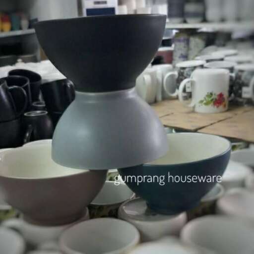a table with a bowl and cups on it.