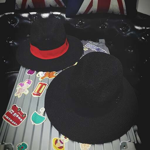 a hat with a red ribbon on top of it.