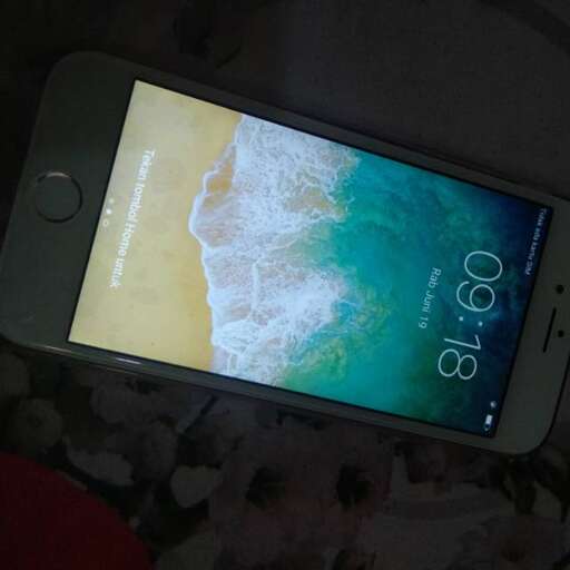 a phone that is on a bed with a beach in the background.