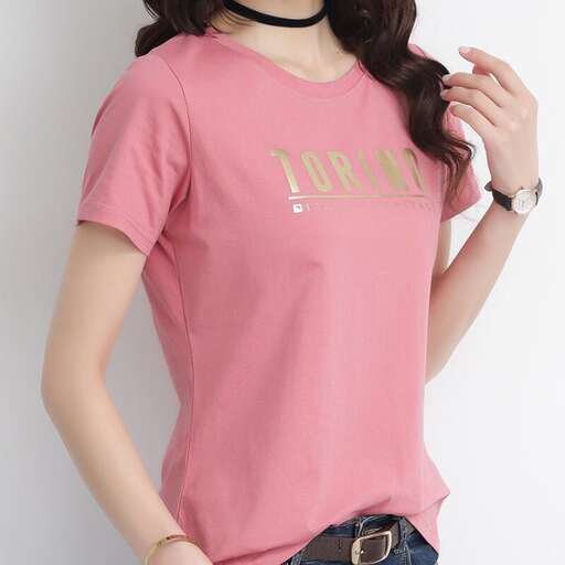 a pink tee with a gold logo on the front.