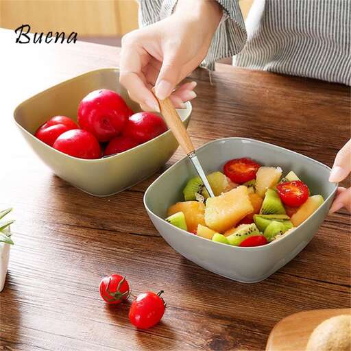 woman cutting vegetables in a bowl with a fork