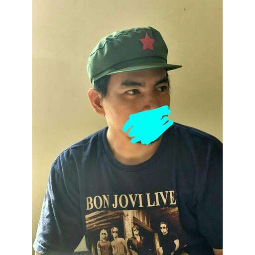 person, a member of the band, is wearing a green cap.