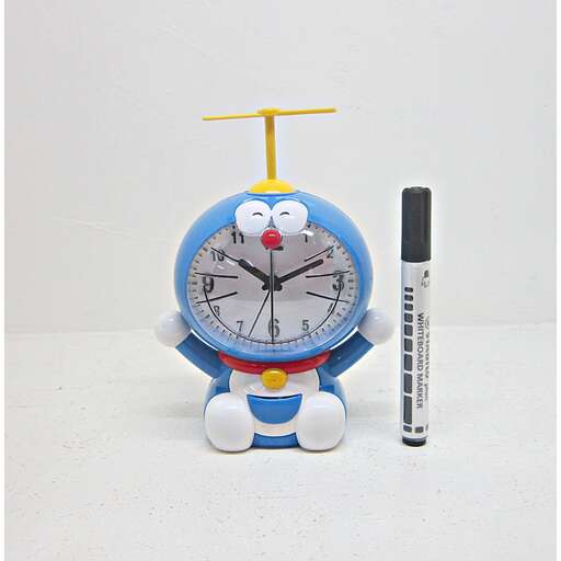 a toy clock with a pencil next to it.