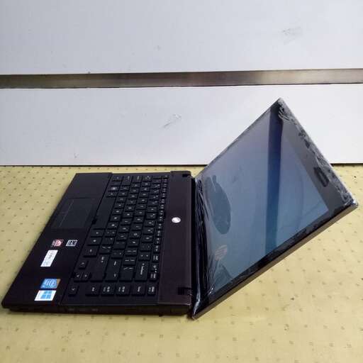 a black laptop computer sitting on top of a yellow table.