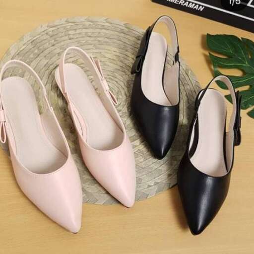 a pair of black shoes sitting on top of a wooden table.