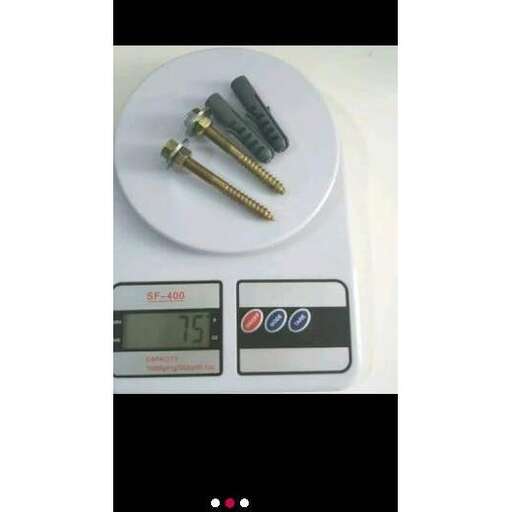 a white plate with a digital clock and a pair of screws.