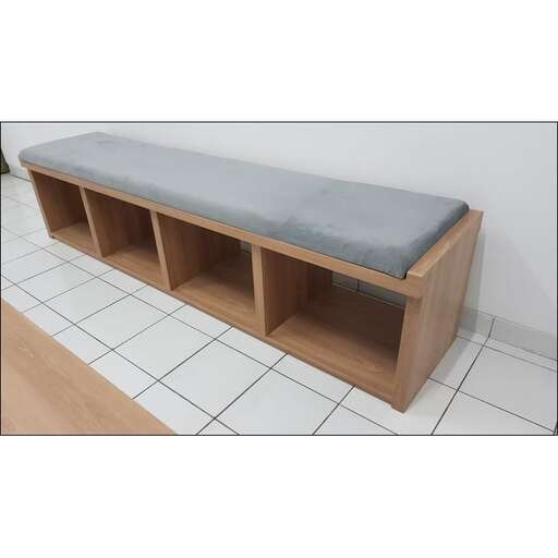 a wooden bench with a gray cushion on it.