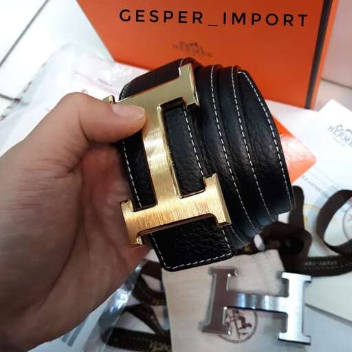 a hand holding a leather wallet with a gold buckle.