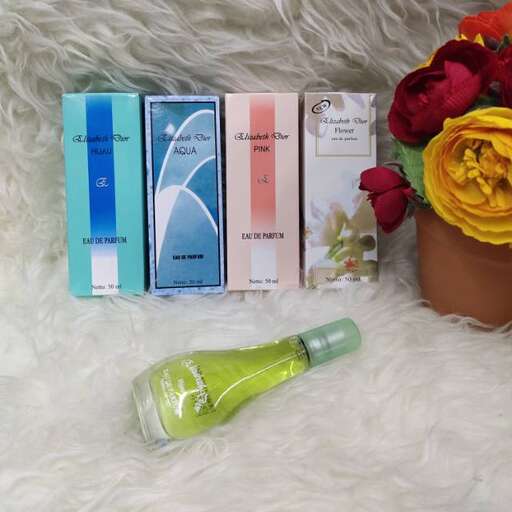 a bottle of perfume sitting on top of a white blanket.
