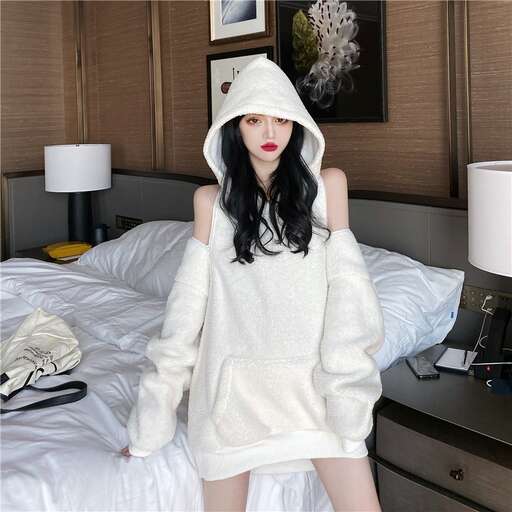 a woman in a white dress is posing on a bed.