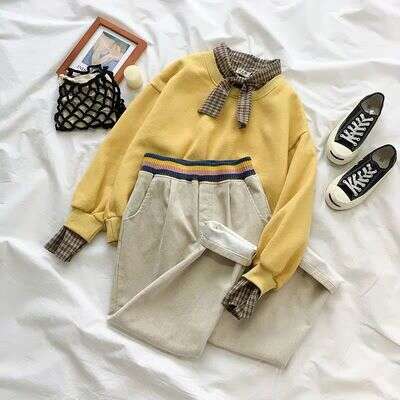 a pair of shoes and a purse on a bed.
