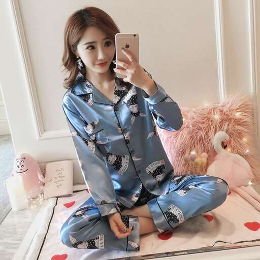 a girl in pajamas sitting on a bed with a stuffed animal.