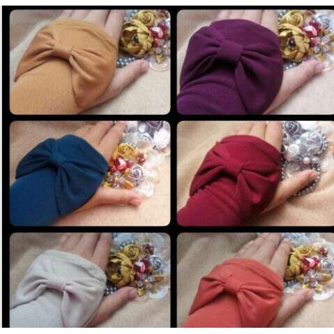a collage of different colored ties on a bed.