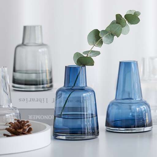 a blue vase with a plant growing out of it.