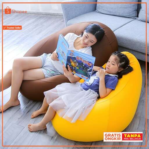 a mother and daughter reading a book on a yellow cushion.