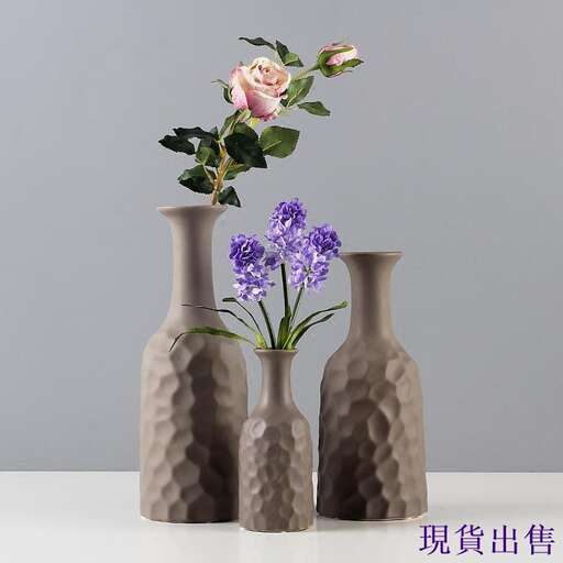 three vases with flowers in them on a table.