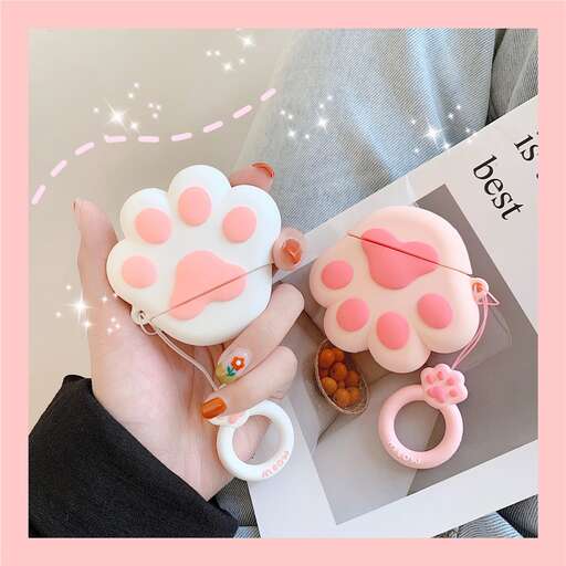 a hand holding a cupcake with a pink paw print on it.