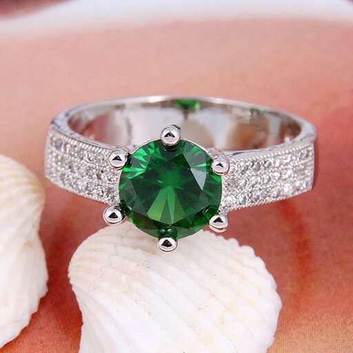 a ring with a green sapphire and diamonds.