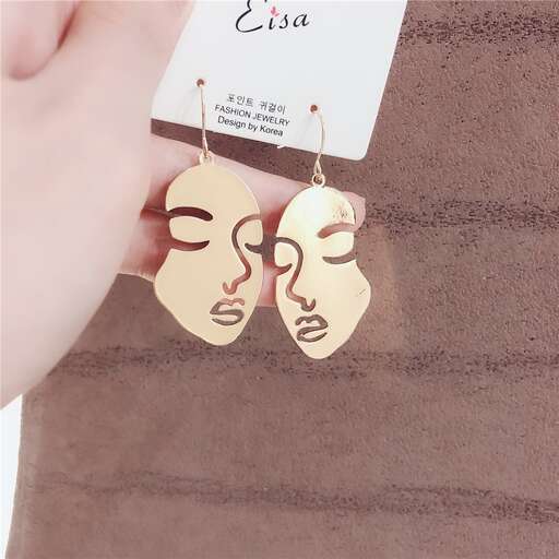 a pair of earrings with a face