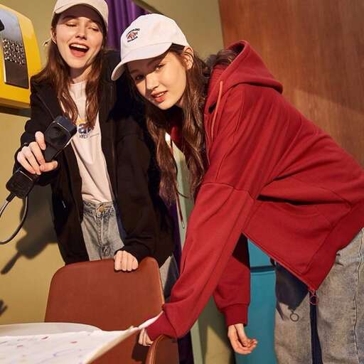two young women standing next to each other at a table.