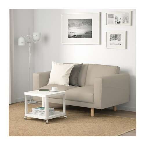 a living room with a couch, table, and pictures on the wall.