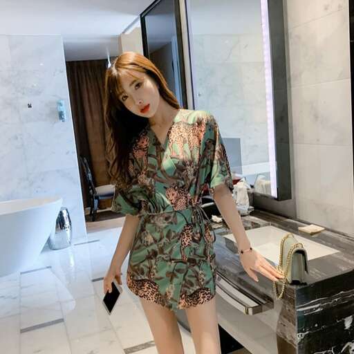 a woman in a floral dress standing in front of a mirror.