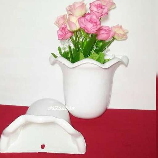 a white vase with pink flowers in it.