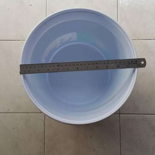 a bucket with a measuring tape on the floor