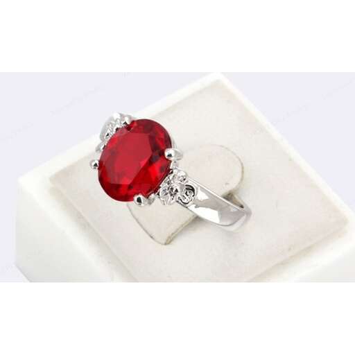 a red sapphire and diamond ring set in sterling silver.