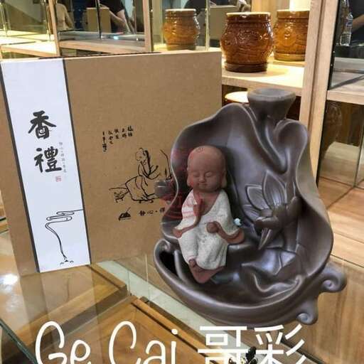 a small statue of a baby sitting on a chair.