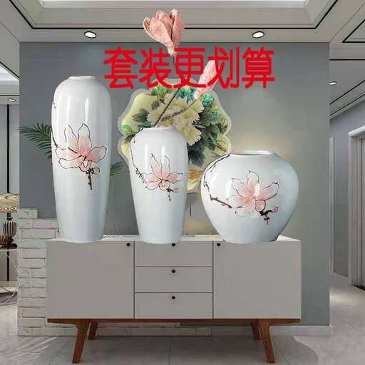 a white vase with flowers on a white dresser.